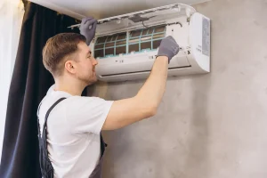 Air conditioning installation process showing indoor unit placement by HVAC technician.